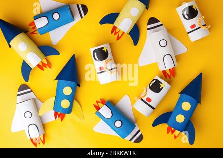 School kindergarten crafts, paper spaceship, shuttle, astronaut on yellow background with copy space for text. Party, start up launch concept, diy, cr Stock Photo