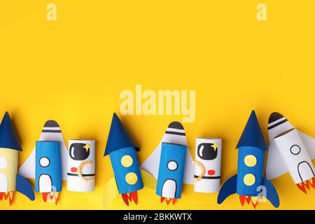 School kindergarten crafts, paper spaceship, shuttle, astronaut on yellow background with copy space for text. Party, start up launch concept, diy, cr Stock Photo