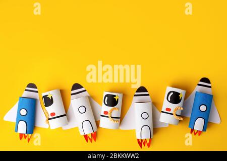 School kindergarten crafts, paper spaceship, shuttle, astronaut on yellow background with copy space for text. Party, start up launch concept, diy, cr Stock Photo