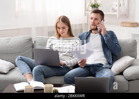 Married partners working from home, communicating with clients by phone Stock Photo