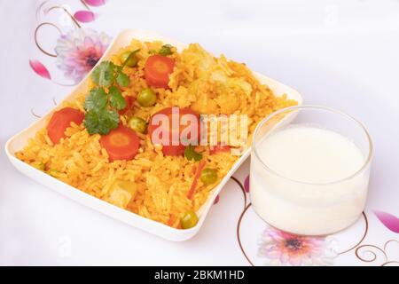 Basmati rice vegetable pulao served in plate with curd Stock Photo