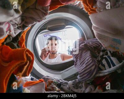 Bearded man using washing machine at home Stock Photo