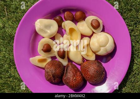 Close up of peeled, cuted and whole pieces of Snake fruit with seed.  Top view of healthy fruit. Salak pondoh is one of the salak cultivars that mostl Stock Photo