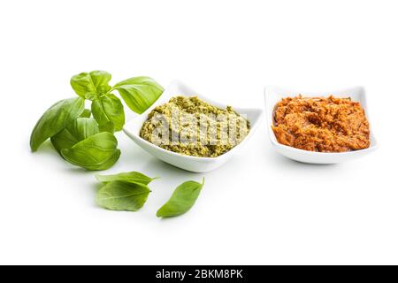 Green basil and red tomato pesto dip sauce  and basil leaves isolated on white background. Stock Photo