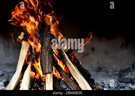 fire flames with sparks on a black background, A fire burns in a fireplace, Fire to keep warm. Stock Photo