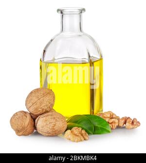 Bottle of walnut oil and walnuts with green leaves Stock Photo