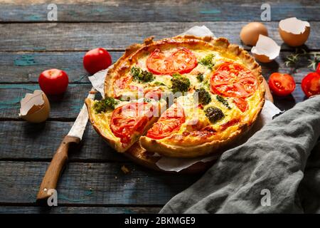 Quiche lorraine with broccoli and cheese on  wooden background. Stock Photo