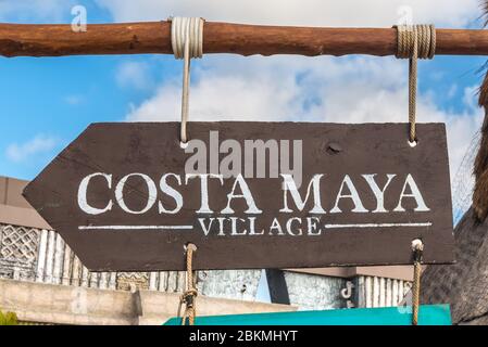 Costa Maya, Mexico - April 25, 2019: Wooden sign board with arrow pointer to the Costa Maya village in port of Costa Maya, Mexico. Stock Photo