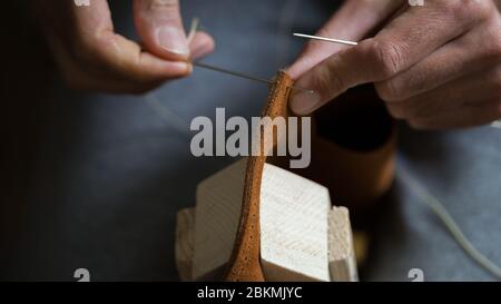 Handmade handicraft leather bag sewing process. Hands working leather Stock Photo