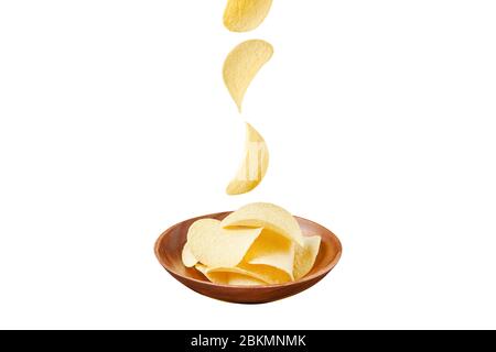 Potato chips in wooden plate falling ones isolated on white background Stock Photo