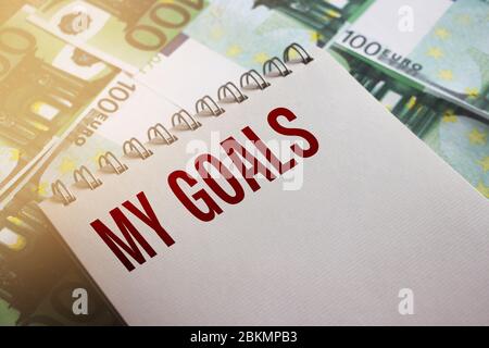 My Goals words on page of copybook put on 100 Euro banknotes. Selective focus. Goal setting business startup concept Stock Photo