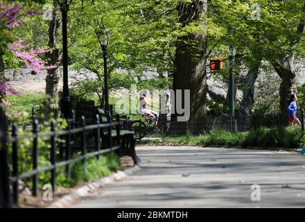 New York, USA. 4th May, 2020. A woman cycles at the Central Park in New York, the United States, May 4, 2020. Amid the ongoing COVID-19 pandemic, New York Governnor Andrew Cuomo on Monday outlined additional guidelines regarding when regions can reopen. According to the Governor's Press Office, the state will monitor four core factors to determine if a region can reopen: number of new infections, health care capacity, diagnostic testing capacity and contact tracing capacity. Credit: Wang Ying/Xinhua/Alamy Live News Stock Photo