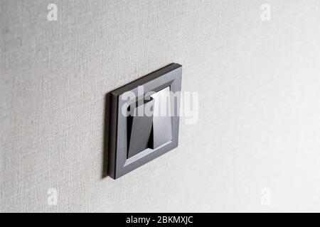 Two-key switch gray on the wall a plastic mechanical switch. Light switch installed after repair. The concept of energy savings. Closeup of Light Swit Stock Photo