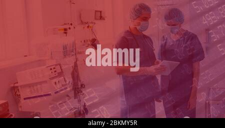 Digital illustration of two doctors standing in a hospital room over data processing Stock Photo