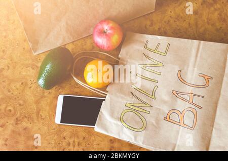 Paper bag with inscription - Online bag, different fresh fruits, vegetables on wooden background. Online shopping and contactless delivery concept. To Stock Photo