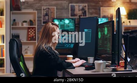 Dangerous cyber criminals working together to bring down the government using super computers. Female hacker. Stock Photo