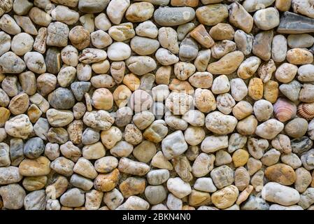 Horizontal color image with a front view of a texture of a wall made of sea stones Stock Photo