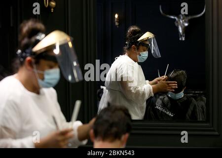 (200505) -- LISBON, May 5, 2020 (Xinhua) -- A hairdresser wearing a face mask cuts the hair of a client at a hairdressing salon in Lisbon, Portugal, May 4, 2020.  Portugal started to revive its economy and society on Monday after nearly 50 days of lockdown under the state of emergency due to the COVID-19 pandemic.   During the phase one of the three-step deconfinement from Monday to May 18, commercial centers up to 200 square meters and street stores are allowed to reopen with strict sanitary measures. (Photo by Pedro Fiuza/Xinhua) Stock Photo