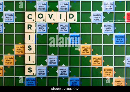 RIGA, LATVIA. 3rd May 2020. COVID name on Scrabble board game. Scrabble is a word game in which two to four players score points by placing tiles, eac Stock Photo