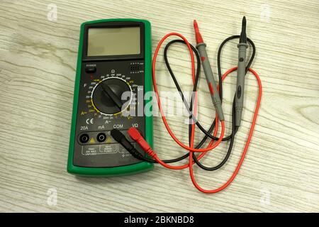 Cropped image of male repairman checking fridge with digital multimeter at home Stock Photo