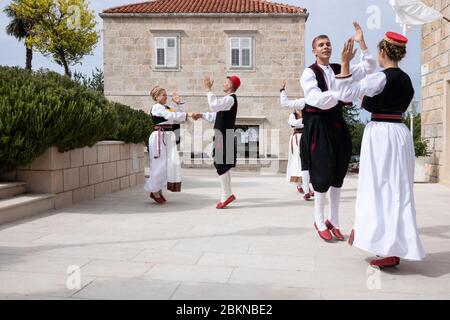 Konavle, Croatia, Oktober 5th 2019. A group of men and woman wearing traditional Croatian folklore costumes while dancing and performing a show in a r Stock Photo