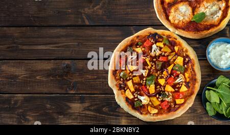 Top view of two home-made vegan pizzas on dark rustic background Stock Photo