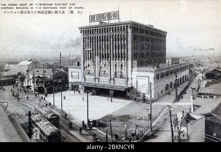 [ 1920s Japan - Japanese Train Station, Osaka ] —   Shin-Keihan Tenjinbashi Station in Osaka. The 7-storey building was opened on October 15, 1925 (Taisho 14) and featured many shops and restaurants, making it a popular destination.  The company was established as Shin-Keihan Tetsudo (新京阪鉄道) in 1922, (Taisho 11). In 1930 (Showa 5), it merged into Keihan Electrical Railway (京阪電気鉄道株式会社), which neatly dates this image to the 1920s.  20th century vintage postcard. Stock Photo