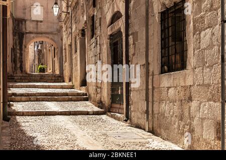 An alley with old limestone pavements in the old town in Dubrovnik, Dalamtia, Croatia on a sunny day in summer. Ancient street with stairs in the medi Stock Photo