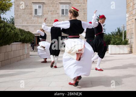 Konavle, Croatia, Oktober 5th 2019. A group of young people wearing traditional Croatian folklore costumes while dancing and performing a show in a ru Stock Photo