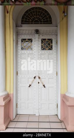 Elegant white ornate door of historic building in European city Odessa of Ukraine. White classic columns by sides of entrance to antique stone house Stock Photo