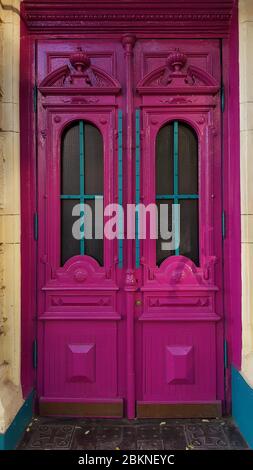 Baroque antique wooden door panels painted in pink purple color with ornate frames and arch windows. Heritage of historic building in European city Od