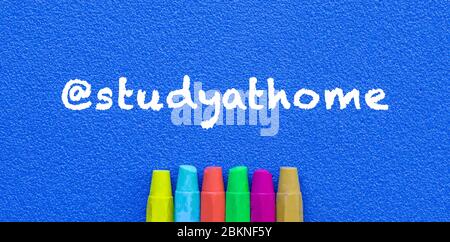 Study at home. Words or typed text on blue board. Colorful crayons. Top view. Education concept.. Stock Photo