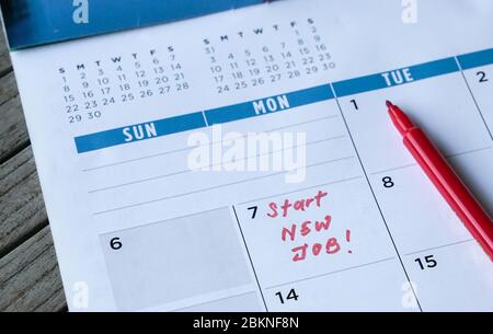 Start new job words written on table calendar with red marker. Employment or careers concept. Stock Photo