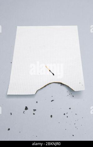 Burned paper sheet and matchstick Stock Photo