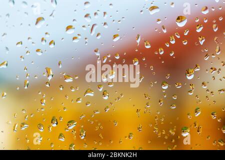 Large raindrops on the windshield of car. Bright building reflected in raindrops on glass. Abstract background. Selective photo Stock Photo