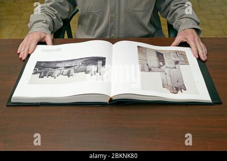 Man looking at old pictures book Stock Photo