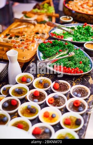 Banquet table with dishes decorated with berries on it Stock Photo