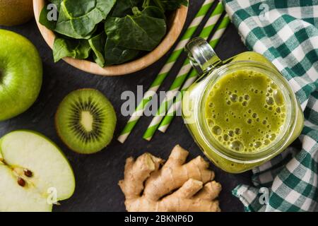 Healthy green smoothie in jar on black stone. Top view Stock Photo