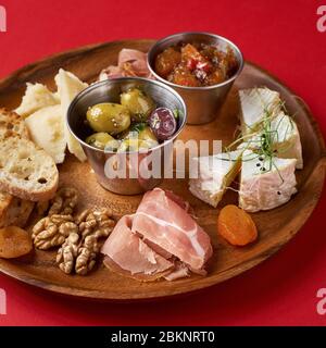 snack set. Variety of cheese, olives, prosciutto, roasted baguette slices, selective focus, square crop. Stock Photo