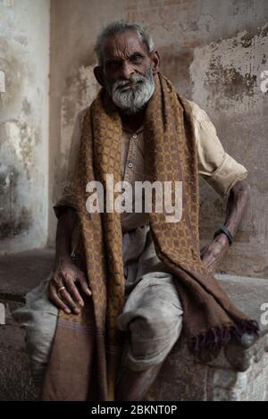 Indian beggar. Bearded old man seated with brown scarf. Jaipur, Rajasthan, India Stock Photo