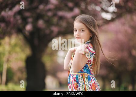 young girl model poses to photographer female kid i beautiful dress outside