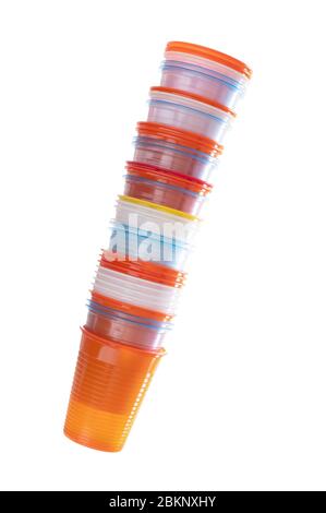 Stack of assorted colourful plastic cups isolated on white background. Disposable, single use items. Stock Photo