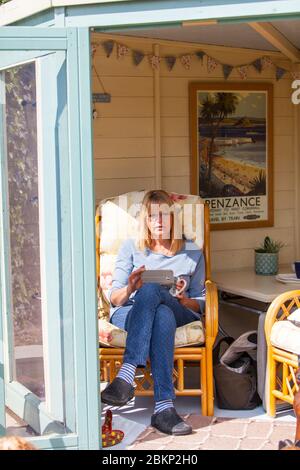 Woman in summerhouse, woman using smartphone, woman sat in summerhouse, woman seated using smartphone, using smartphone, in summerhouse, summerhouse Stock Photo