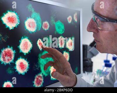 Pharmaceutical research into diseases and pandemics. Scientist viewing a image of virus using a electron microscope in the laboratory. Stock Photo
