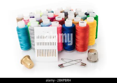 tailor needles and threads over white background Stock Photo