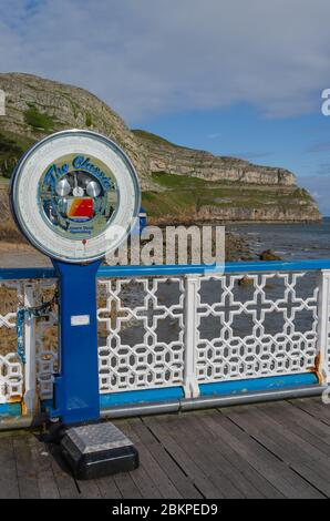 Llandudno, UK : May 6, 2019: A traditional British public weigh machine on Llandudno Pier allows people to find their weight whilst enjoying vews of t Stock Photo