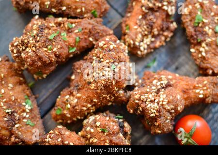 Baked chicken wings with sesame seeds. Ketchup and chili sauce. Close up. Top view. Delicious fried chicken wings. Stock Photo