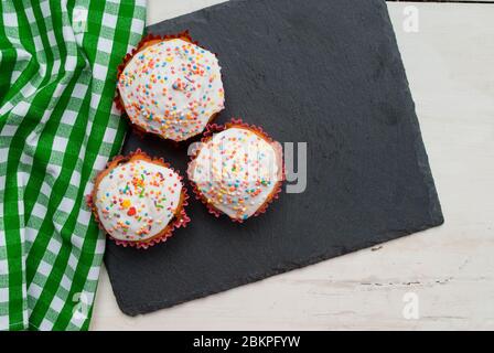 Three homemade muffins on a gray board Stock Photo