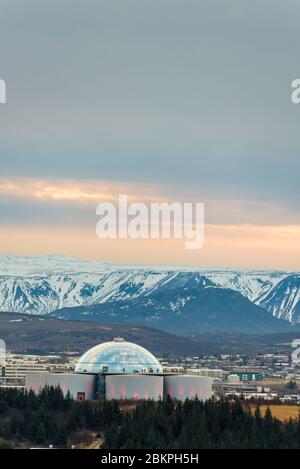 Perlan, landmark building in Reykjavík, the capital of Iceland with snowy mountains in the background, seen from the tower of Hallgrimskirkja church. Stock Photo