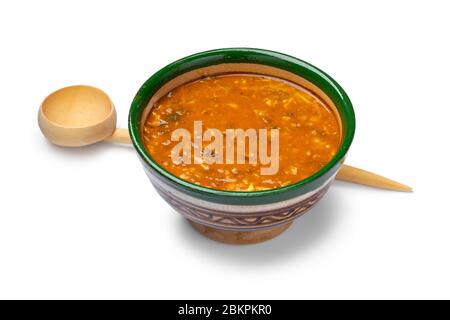 Single traditional bowl of Moroccan harira and wooden spoon close up for iftar in ramadan isolated on white background Stock Photo